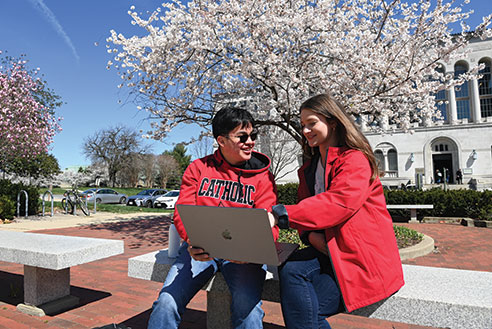 Two students sitting outside. Links to What to Give
